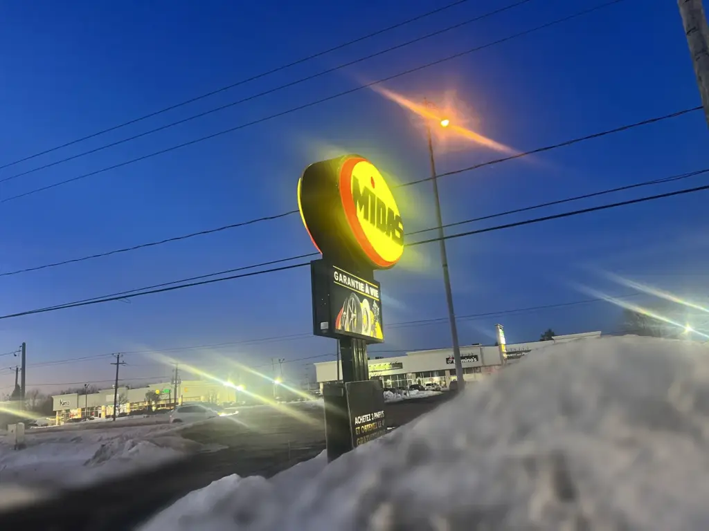 Midas sign lit up on a winter evening in Saint-Constant